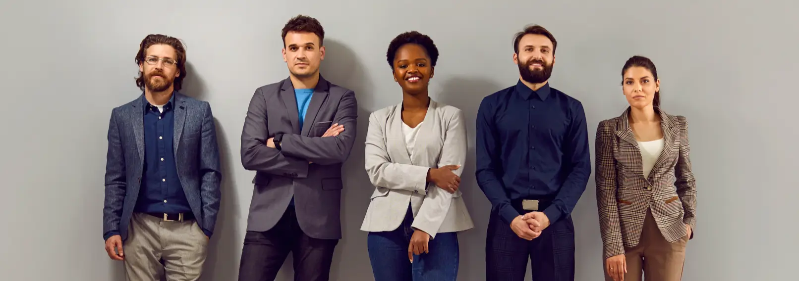 Five male and female co-workers dressed for a consistent business casual dress code.