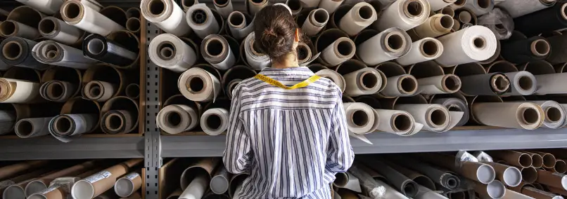 Woman standing in front of warehouse paper tubes
