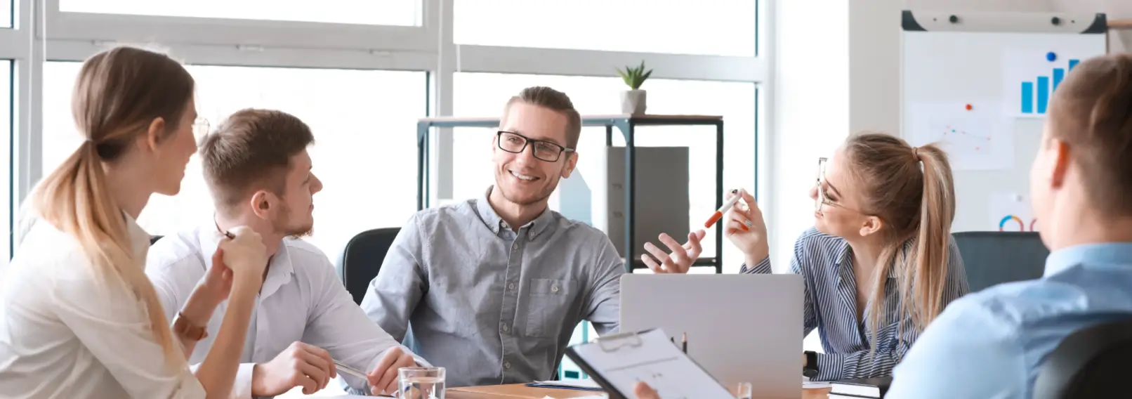 Five casually dressed co-workers during a lively meeting.